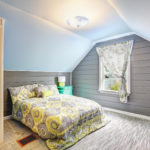 Bedroom with vaulted ceiling and plank paneled walls