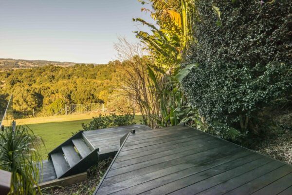 podest tarasowy z desek w odcieniu ciemnego brązu na tle terenów zielonych